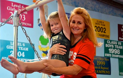 Flips Preschooler on the bars with Ms. Susan
